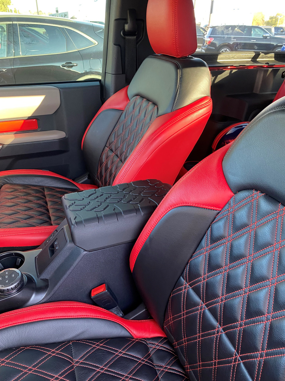 Interior of a vehicle with black and red diamond-stitched seats